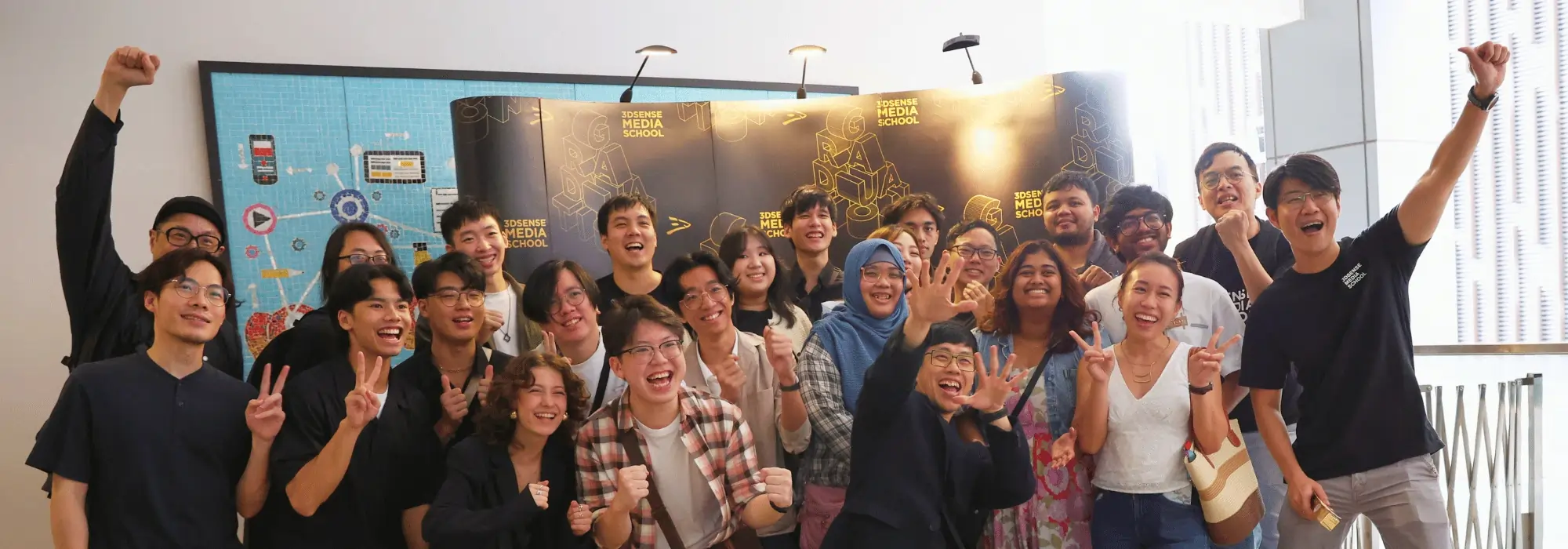 Students and lecturers celebrating together at 3dsense Graduation Day, posing in front of the 3dsense graduation backdrop.